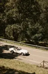 Recién casados conduciendo un descapotable clásico.